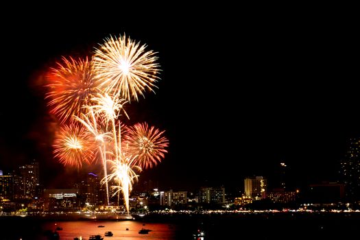 Many flashing fireworks with night cityscape background celebrate New Year.
