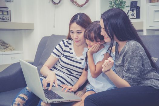 Mother, Aunt and kid having time together lerning with using laptop computer at home with relax and happy on couch, education and lifestyle concept.