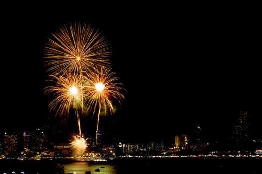 Many flashing fireworks with night cityscape background celebrate New Year.