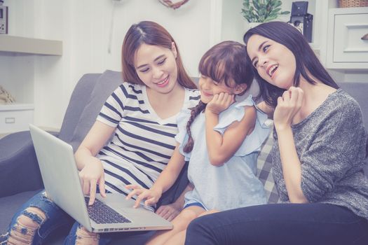 Mother, Aunt and kid having time together lerning with using laptop computer at home with relax and happy on couch, education and lifestyle concept.