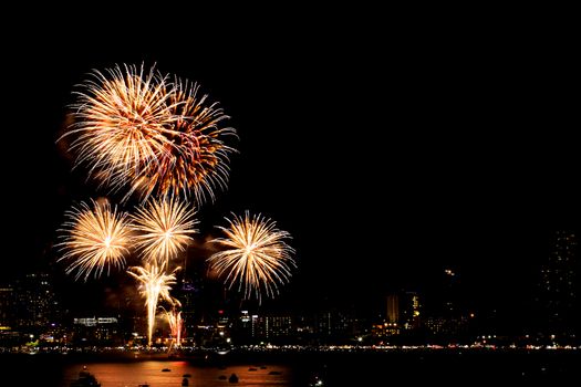 Many flashing fireworks with night cityscape background celebrate New Year.