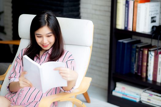 Beautiful of portrait young asian woman relax sitting reading book in living room at home, girl study literature, education and llifestyle concept.