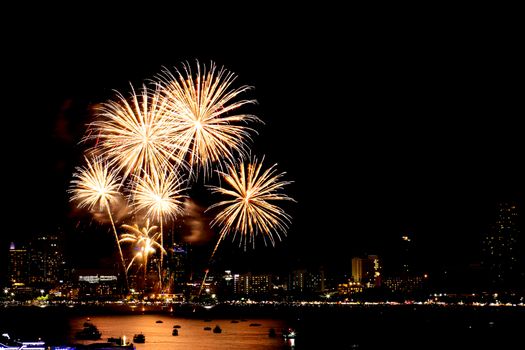Many flashing fireworks with night cityscape background celebrate New Year.