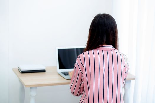 Beautiful of portrait asian young woman working online on laptop computer sitting at living room, professional female freelancer using notebook with connect to internet for distance job.