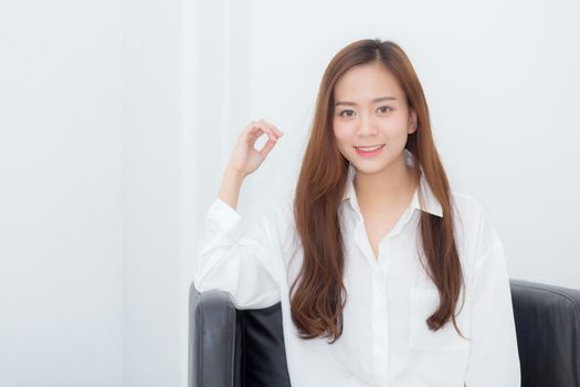Portrait of beautiful young asian woman smile and happy sitting on chair in the living room at home, lifestyle and relax concept.