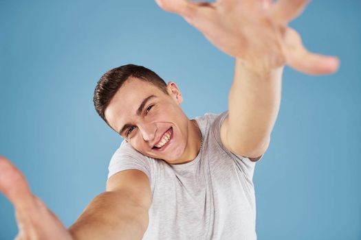 Emotional man in white t-shirt cropped view on blue background lifestyle. High quality photo