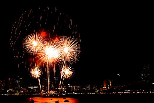 Many flashing fireworks with night cityscape background celebrate New Year.
