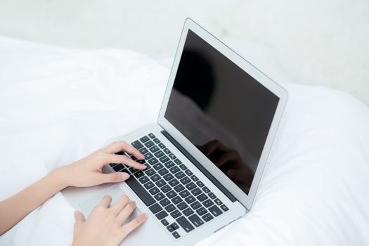 Closeup young asian woman using laptop for leisure on bedroom, girl working online with notebook freelance, business concept.