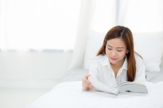 Beautiful of portrait young asian woman relax lying reading book on bedroom at home, girl study literature, education and lifestyle concept.