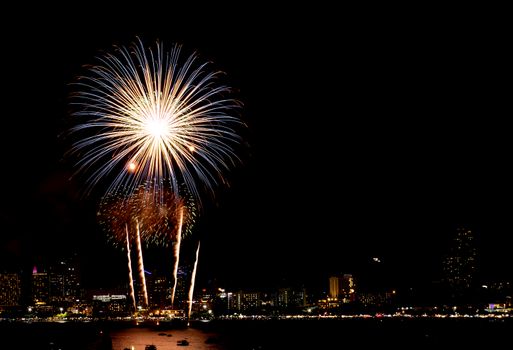 Many flashing fireworks with night cityscape background celebrate New Year.