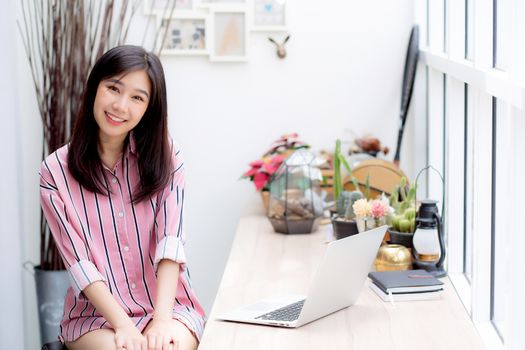 Beautiful of portrait asian young woman working online on laptop sitting at coffee shop, professional female freelancer using notebook computer with connect to internet for distance job.
