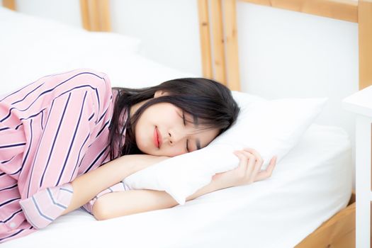 Portrait of beautiful asian young woman sleep lying in bed with head on pillow comfortable and happy with leisure, girl with relax  for health and lifestyle concept.