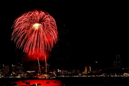 Many flashing fireworks with night cityscape background celebrate New Year.