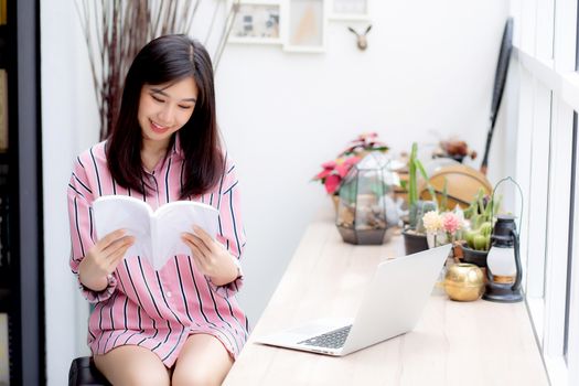 Beautiful of portrait young asian woman relax sitting reading book in living room at home, girl study literature, education and llifestyle concept.