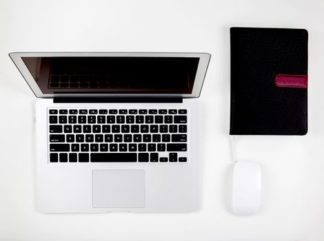 Top view of laptop computer with open display screen monitor, mouse and book isolated on white background, notebook or netbook with keyboard, communication technology concept.