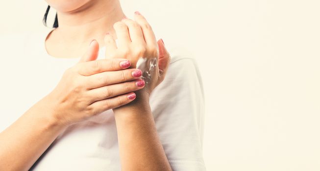 Closeup young Asian woman applying lotion cosmetic moisturizer cream on her behind the palm skin hand, studio shot isolated on white background, Healthcare medical and hygiene skin body care concept