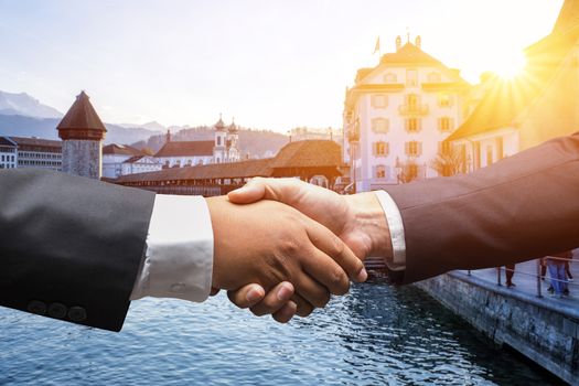businessmen shaking hands on Lucerne, Switzerland background