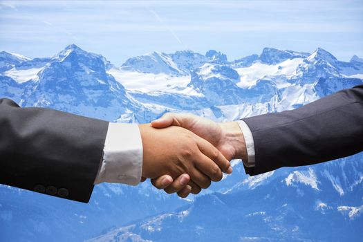 businessmen shaking hands on Snow mountain in Switzerland background