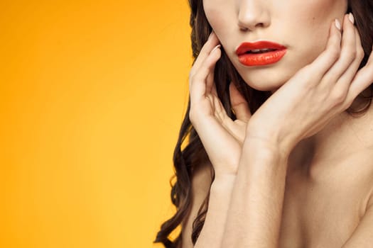 beautiful brunette red lips bare shoulders skin care yellow background. High quality photo