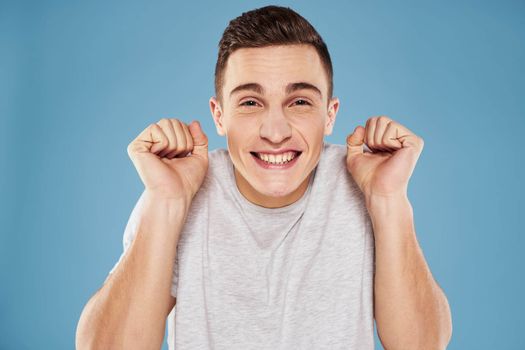 Emotional man in white t-shirt cropped view on blue background lifestyle. High quality photo