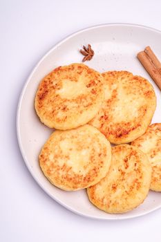 Cottage cheese fritters. Christmas breakfast mood with anise and cinnamon on white background, top view