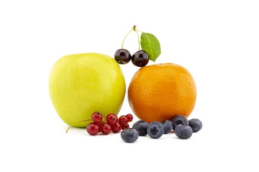 Fresh seasonal fruit still life with assorted berries including blueberries, cherries and red currants with apple and orange on a white background