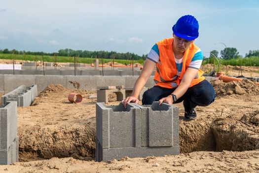 building the foundation of a building with lost formwork by a young construction engineer.