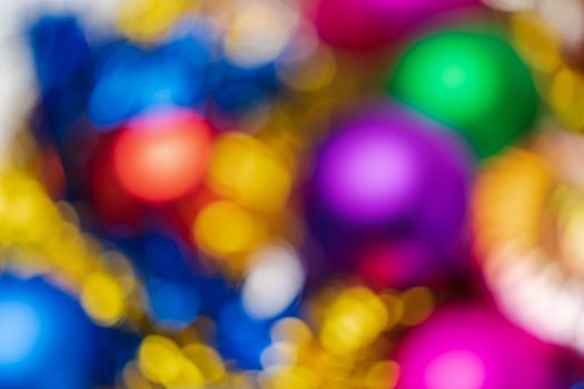 Defocused shining Christmas balls holiday decorations, abstract blurry bokeh background effect. Out of focus glowing lights celebration texture for use at graphic design.