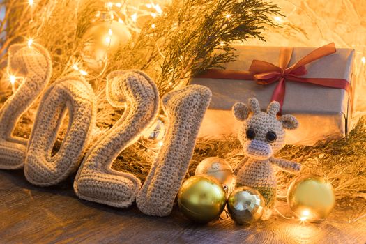 Happy Chinese New Year 2021 composition with crochet numbers 2021 gift box, toy bull, and garland decor