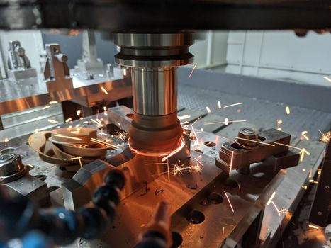 cnc milling of hardened steel with sparks - closeup with selective focus and blur.