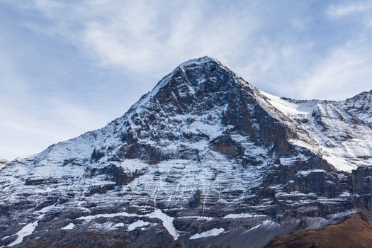 Stunning close up view of famous Eiger north face of Swiss Alps on Bernese Oberland  with glacier and snow on cloudy autumn day, Canton of Bern, Switzerland