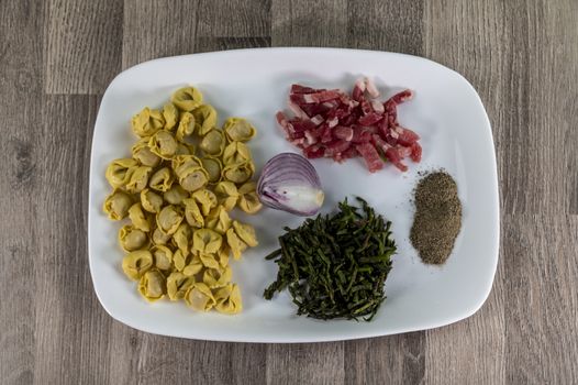 ingredients for cappelletti pancetta and asparagus creamed in a pan with parmesan