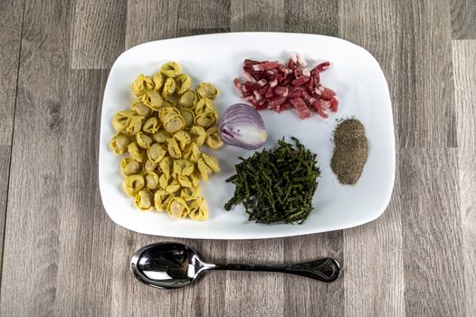 ingredients for cappelletti pancetta and asparagus creamed in a pan with parmesan