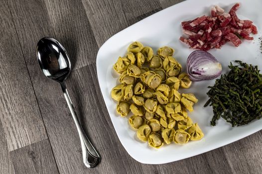 ingredients for cappelletti pancetta and asparagus creamed in a pan with parmesan