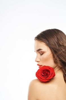 Portrait of woman with red rose naked shoulders Make-up on brunette face. High quality photo