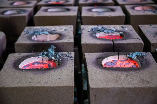 Cooling process of filled sand molds after steel casting, cracked during the process. Close-up view on rows on the factory floor.