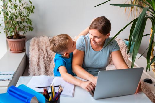 Mother with kid trying to work from home during quarantine. Stay at home, work from home concept during coronavirus pandemic