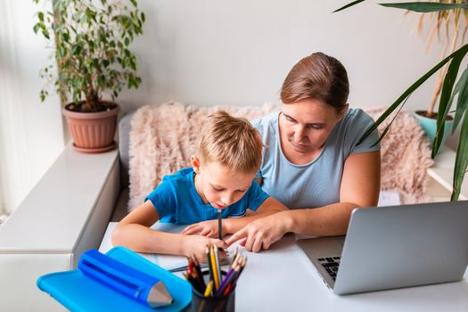 Mother with kid trying to work from home during quarantine. Stay at home, work from home concept during coronavirus pandemic