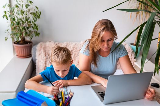 Mother with kid trying to work from home during quarantine. Stay at home, work from home concept during coronavirus pandemic