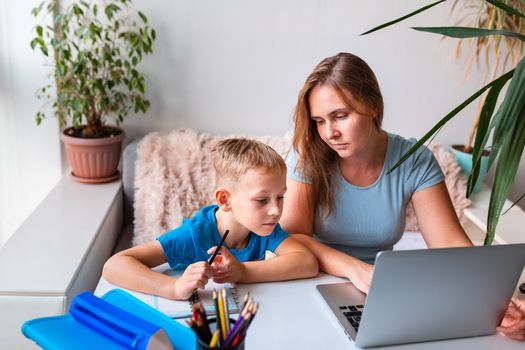 Mother with kid trying to work from home during quarantine. Stay at home, work from home concept during coronavirus pandemic