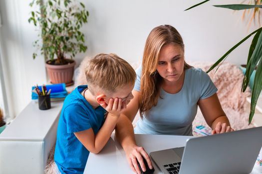 Mother with kid trying to work from home during quarantine. Stay at home, work from home concept during coronavirus pandemic