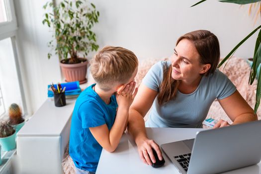 Mother with kid trying to work from home during quarantine. Stay at home, work from home concept during coronavirus pandemic