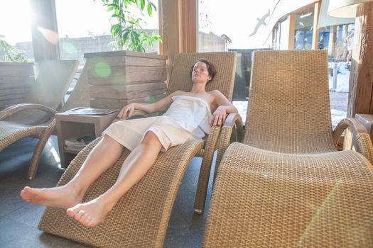 woman relaxes after sauna in relaxation room.