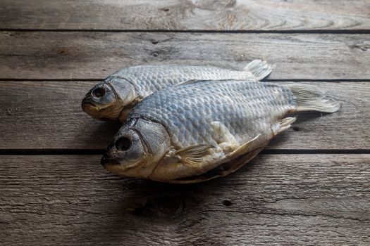 Salted Dry fish vobla on wooden background, delicious beer snack, close-up.