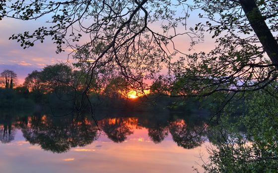 Beautiful and romantic sunset at a lake in stunning yellow and orange colors