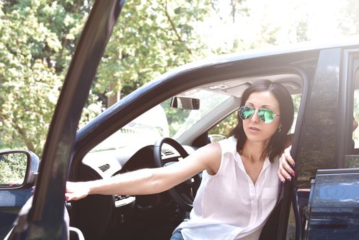 Beautiful middle-aged caucasian woman stepping out the car