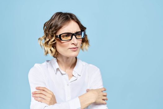 Business woman in a light shirt on a blue background gestures with her hands emotions model work. High quality photo