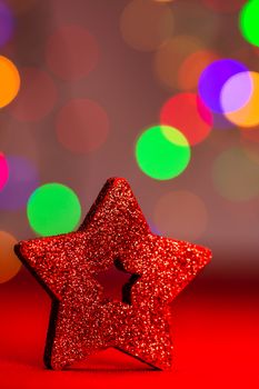 Red glittery decoration in a colorful Christmas composition isolated on background of blurred lights.