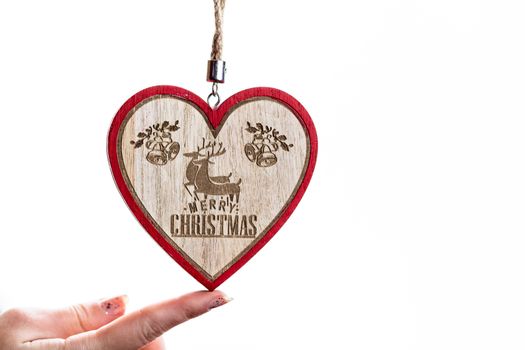 Hand holding heart shaped Christmas decoration isolated on white.