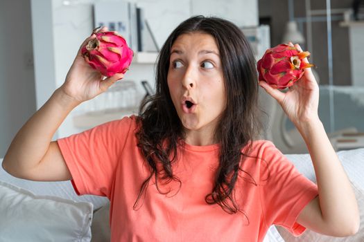 Girl and dragon fruit. Joyful girl enjoying tropical fruits.